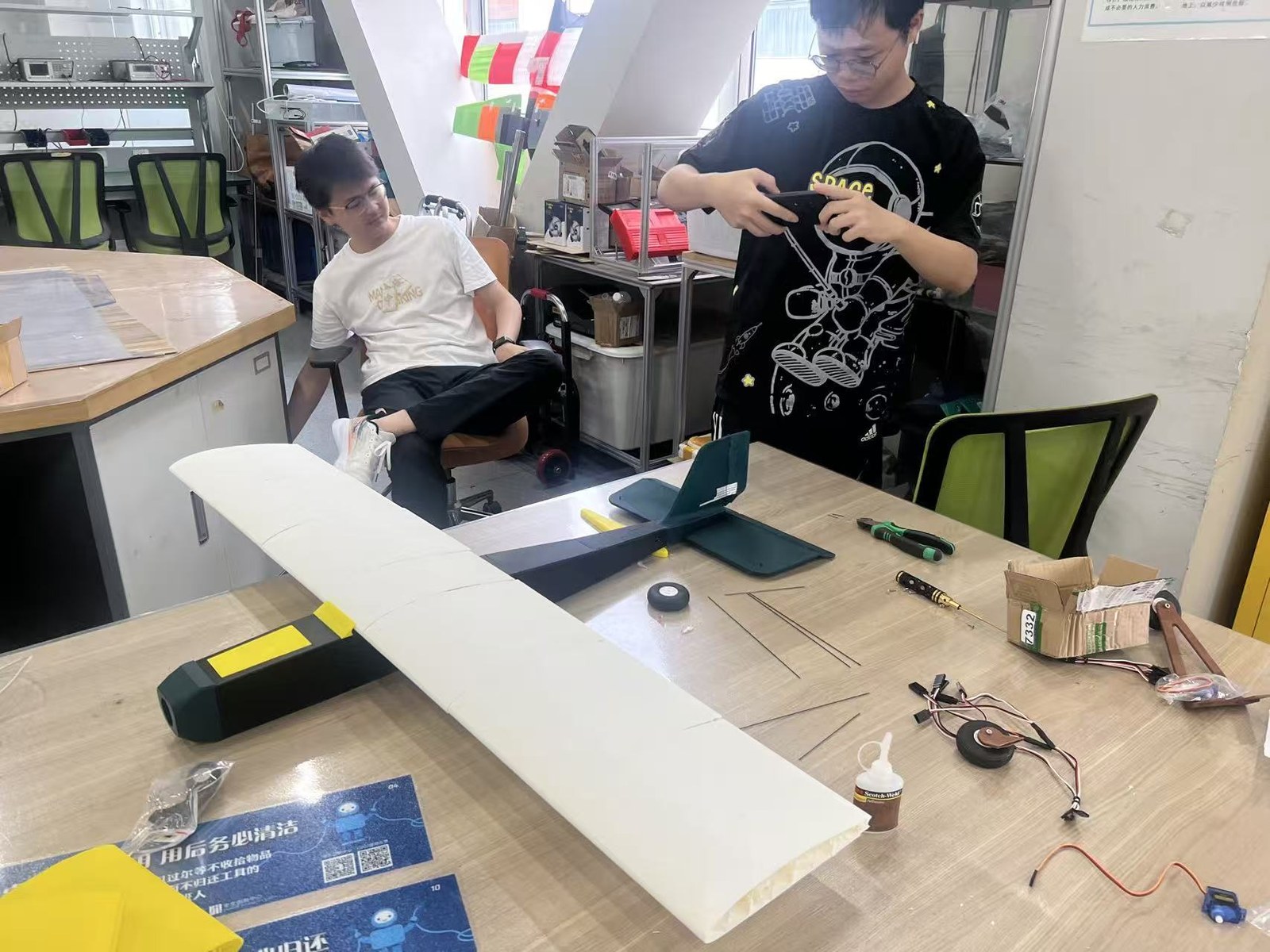 Fixed-wing RC aircraft being assembled on a workshop table