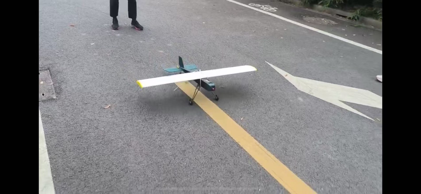 Completed fixed-wing RC aircraft on its landing gear on a paved road