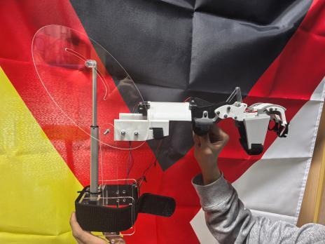 Assembled rehabilitation robot held horizontally with motor electronics and hand linkage visible